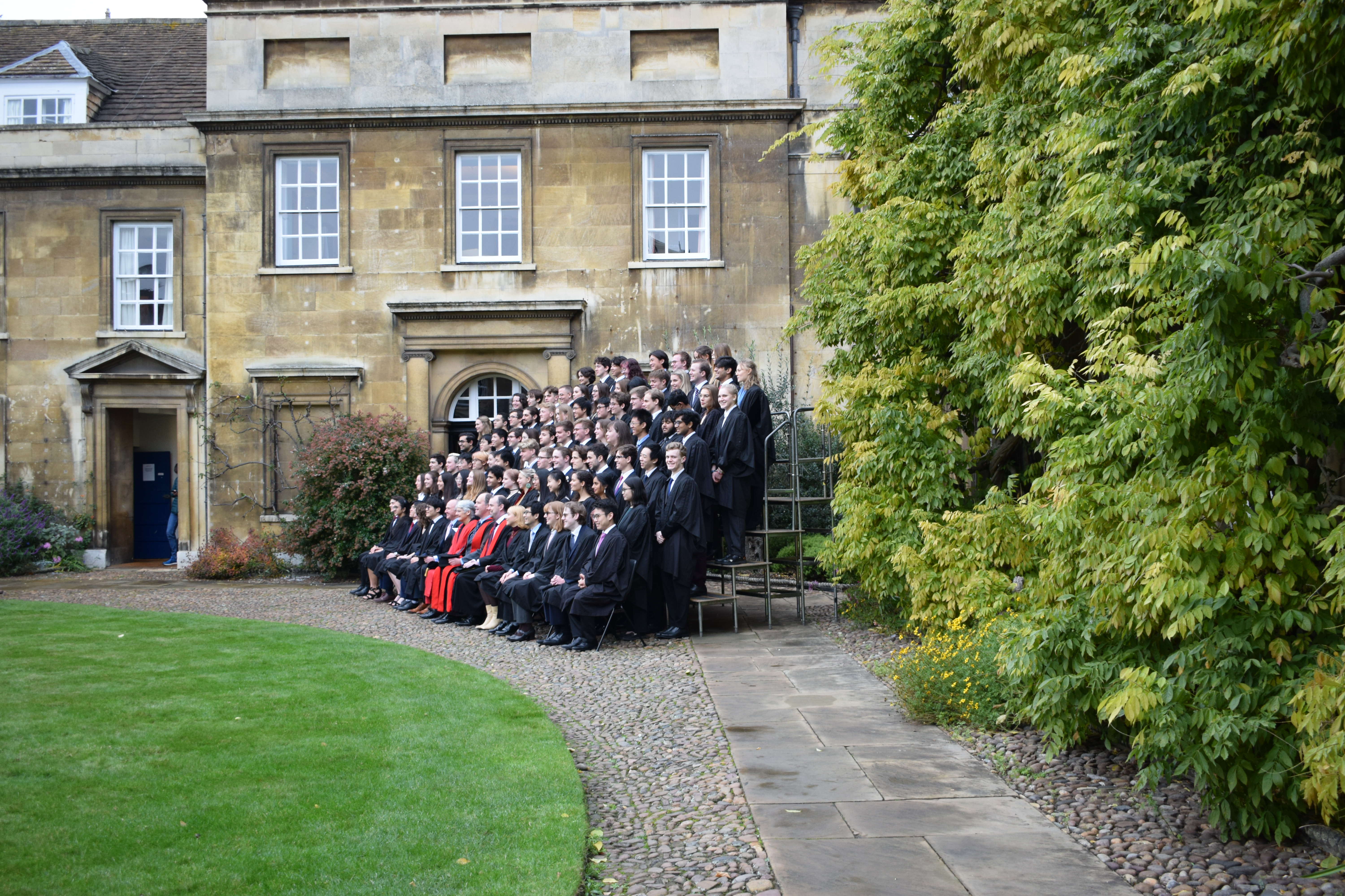 Scholars stand on tiered stands for an official photograph